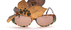 Artistically crafted acetate sunglasses with large gold leaf, rhinestone decor in green and gold in the leaf