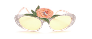 A light pink tinted flower adorned with brown rhinestones and embedded in green