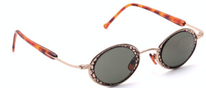 Oval gold metal sunglasses with a patterned inlay and 100% UV protection