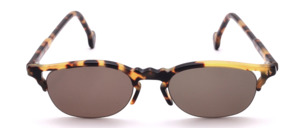Oval tortoiseshell coloured semi-rimless sunglasses featuring an elegant 90s vintage-style design without nose pads; grey lenses; Made in Germany