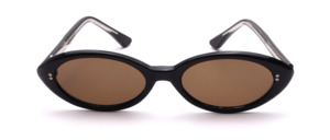 Vintage black cat-eye sunglasses with brown lenses and small silver decorative rivets at the temple hinges; manufactured in the 1960s